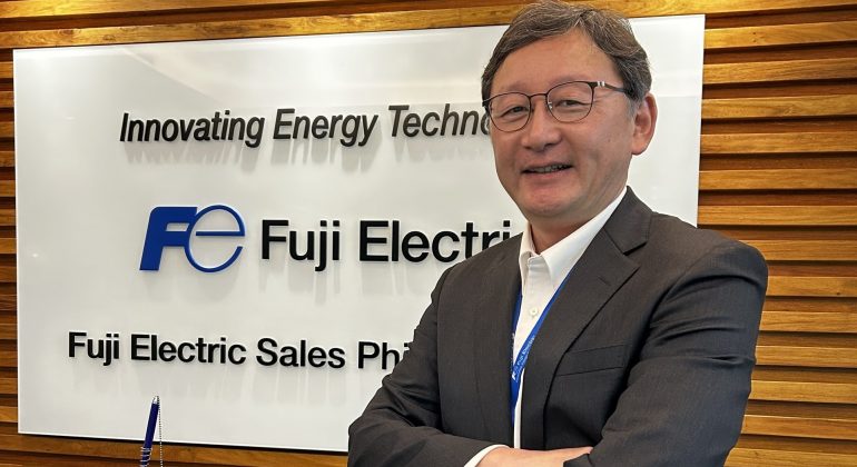 Mr. Ishikawa poses in front of the Fuji Electric PH banner in this photo.