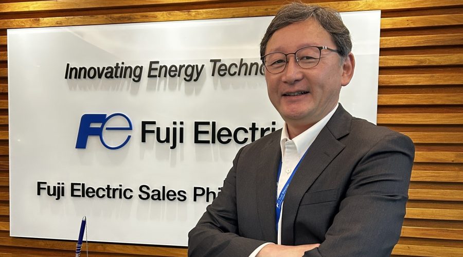 Mr. Ishikawa poses in front of the Fuji Electric PH banner in this photo.